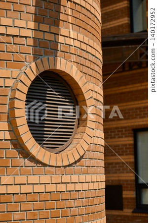 Unique round vent on brick wall shines Unique round vent on brick wall shines 140172952