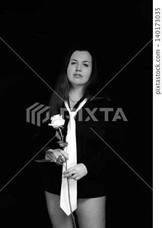 portrait of a brunette in a black shirt with a tie and a white rose portrait of a brunette in a black shirt with a tie and a white rose 140173035