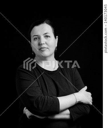 black and white studio portrait of a confident woman with crossed arms over her chest black and white studio portrait of a confident woman with crossed arms over her chest 140173045