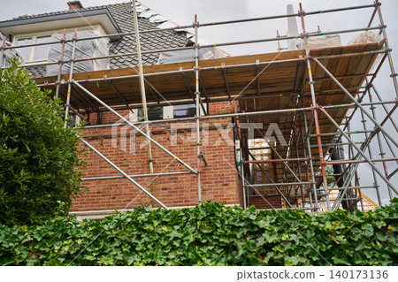 Scaffolding Surrounds a Brick Building Undergoing Renovation in the Heart of Amsterdam's Vibrant City Center Scaffolding Surrounds a Brick Building Undergoing Renovation in the Heart of Amsterdam's Vibrant City Center 140173136