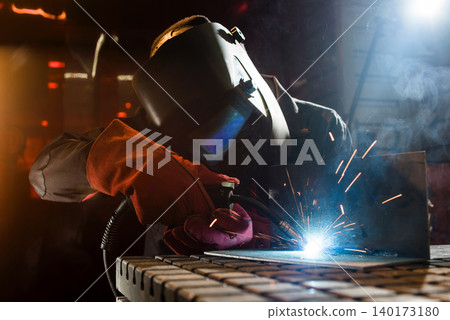 Sparks fly in a busy welding workshop at night Sparks fly in a busy welding workshop at night 140173180