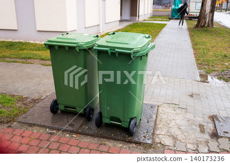 Two green trash bins on a rainy day Two green trash bins on a rainy day 140173236