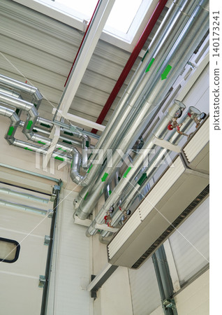 Industrial piping system under bright skylight Industrial piping system under bright skylight 140173241