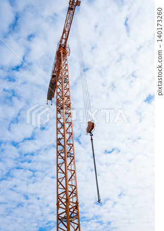 Tall crane reaches for the sky in urban landscape Tall crane reaches for the sky in urban landscape 140173260