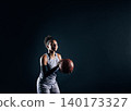 Young sportswoman in uniform preparing to throw a ball against a black background 140173327