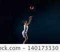 Side view of a basketball woman throwing a ball up in the studio 140173330