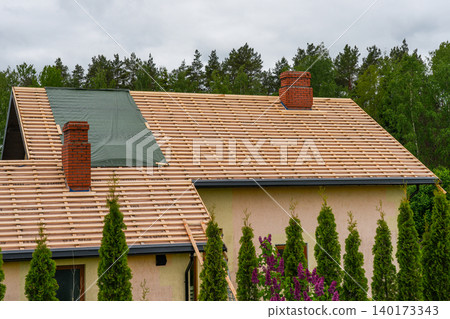 Residential house roof under renovation with battens and underlayment before tile installation work Residential house roof under renovation with battens and underlayment before tile installation work 140173343