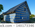 House facade under renovation with wind barrier membrane and timber battens for exterior cladding 140173346