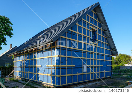 House facade under renovation with wind barrier membrane and timber battens for exterior cladding House facade under renovation with wind barrier membrane and timber battens for exterior cladding 140173346