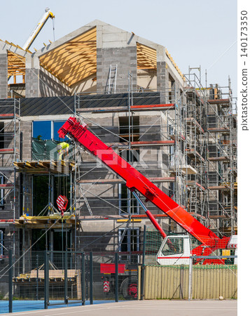 Multi family residential building construction with crane scaffolding and timber roof structure Multi family residential building construction with crane scaffolding and timber roof structure 140173350