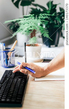 A man types on a keyboard and works with financial data A man types on a keyboard and works with financial data 140173370