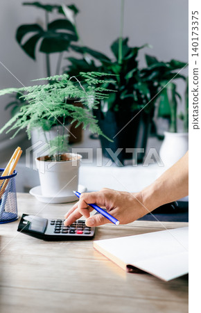 A man makes calculations based on accounting data using a calculator A man makes calculations based on accounting data using a calculator 140173375