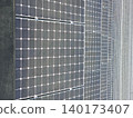 Photovoltaic panels cover modern building exterior in repeating rows 140173407