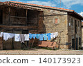 Clothesline hanging on a rustic stone house facade with wooden windows in Spain 140173923