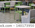 Green Chairs and Tables Inviting Relaxation in Charming City Center 140173950