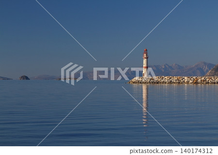 Seascape at sunshine. Lighthouse and sailings on the coast. Seaside town of Turgutreis and spectacular sunshine Seascape at sunshine. Lighthouse and sailings on the coast. Seaside town of Turgutreis and spectacular sunshine 140174312
