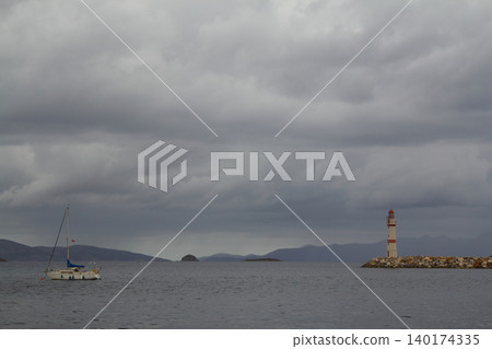 A sailing boat sailing in a stormy weather in Bodrum's Turgutreis district. A sailing boat sailing in a stormy weather in Bodrum's Turgutreis district. 140174335