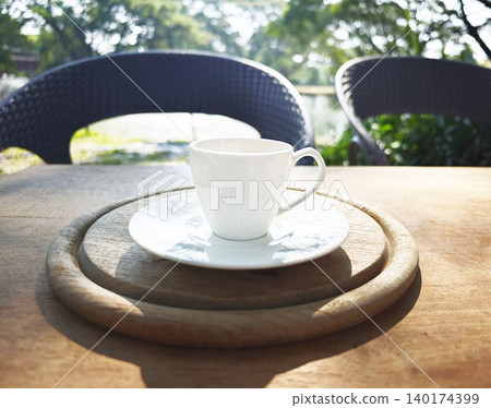 Morning coffee in a peaceful garden  where every sip feels like a quiet breath for the soul. 140174399