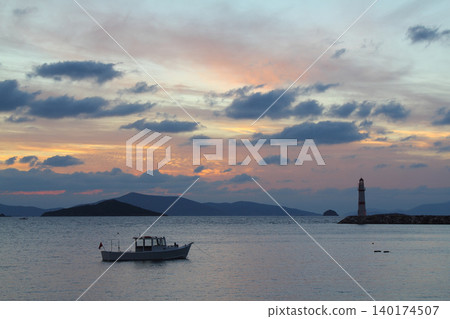 Seascape at sunshine. Lighthouse and sailings on the coast. Seaside town of Turgutreis and spectacular sunshine Seascape at sunshine. Lighthouse and sailings on the coast. Seaside town of Turgutreis and spectacular sunshine 140174507