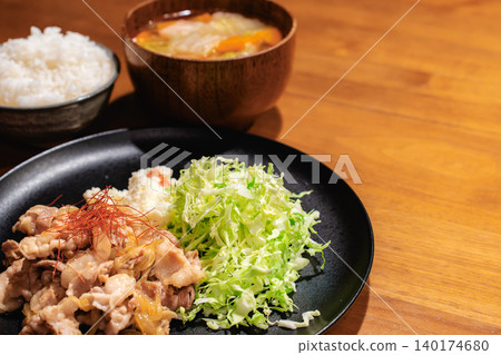 Pork ginger stir-fry set meal on a wooden table Pork ginger stir-fry set meal on a wooden table 140174680