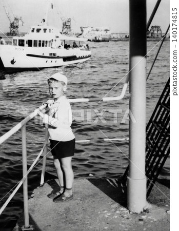 Young boy standing on a pier during a family trip in Crimea in 1971 140174815
