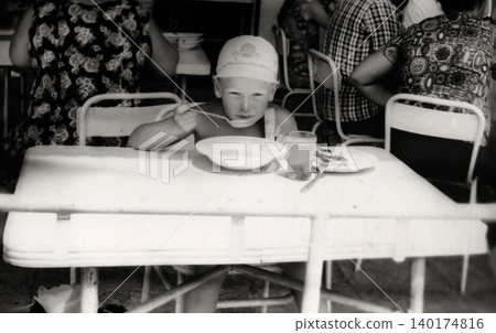 Young boy having a meal in a Soviet resort cafeteria during a family trip in Crimea in 1971 Young boy having a meal in a Soviet resort cafeteria during a family trip in Crimea in 1971 140174816