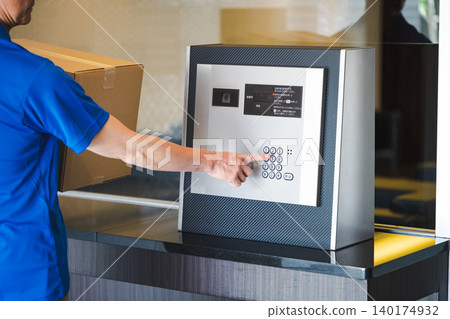 A delivery man rings the doorbell at an apartment building. A delivery man rings the doorbell at an apartment building. 140174932