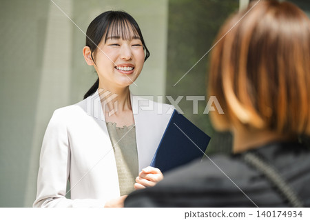 一位從事房地產銷售的年輕職業女性正在與客戶交談。 一位從事房地產銷售的年輕職業女性正在與客戶交談。 140174934