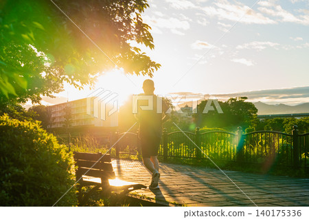 A person bathed in the strong summer sun at sunset. A person bathed in the strong summer sun at sunset. 140175336