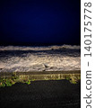 The dynamic scenery of rough waves and whitecaps crashing against the shore at night. 140175778