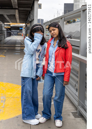 Two teenagers in blue and red jackets pose for a picture Two teenagers in blue and red jackets pose for a picture 140175911
