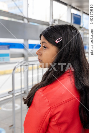 A teenager with long hair is wearing a red jacket and pink hair clips 140175916