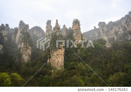 Pillars of the Tianmenshan Mountains rising from the jungle in the fog near Zhangjiajie, China Pillars of the Tianmenshan Mountains rising from the jungle in the fog near Zhangjiajie, China 140176261