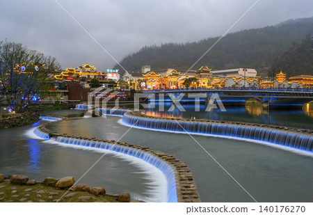 ZHANGJAJIE, China. Evening view of the bridge over the Suoxi River and the lights of the city in fog ZHANGJAJIE, China. Evening view of the bridge over the Suoxi River and the lights of the city in fog 140176270