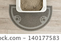 Multi-cat litter mat with paw print design positioned under a white litter box filled with gray cat litter on a wooden floor 140177583