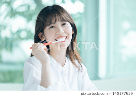Oral care: A woman brushing her teeth. Oral care: A woman brushing her teeth. 140177639
