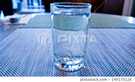 close-up photo of a glass of water on a white table close-up photo of a glass of water on a white table 140178126