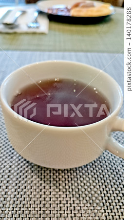 close up photo of a cup of tea on a white table close up photo of a cup of tea on a white table 140178288