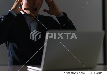 一個面目模糊的男人,在昏暗的房間裡盯著筆記型電腦,對事態的意外發展感到震驚和沮喪,舉起了手。 一個面目模糊的男人,在昏暗的房間裡盯著筆記型電腦,對事態的意外發展感到震驚和沮喪,舉起了手。 140178855