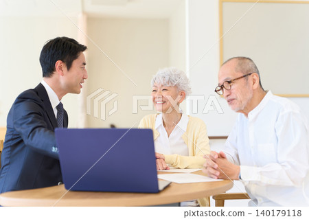 Asian businessmen selling to seniors Asian businessmen selling to seniors 140179118