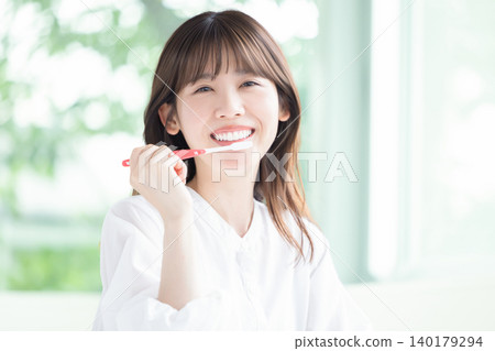 Oral care: A woman brushing her teeth. 140179294