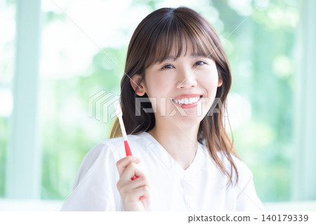 Oral care: A woman brushing her teeth. 140179339