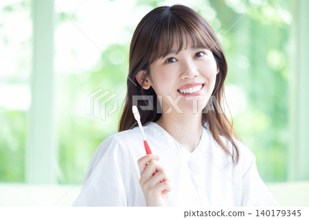 Oral care: A woman brushing her teeth. Oral care: A woman brushing her teeth. 140179345