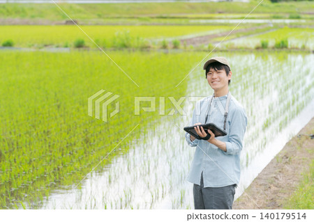 A young man uses a tablet to farm. 140179514