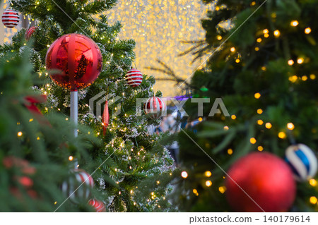 two christmas trees decorated with red and white balls with a giant wall of glowing golden lights in the middle two christmas trees decorated with red and white balls with a giant wall of glowing golden lights in the middle 140179614