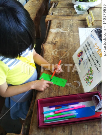A little girl making a Tanabata wish with her left hand. A little girl making a Tanabata wish with her left hand. 140179659