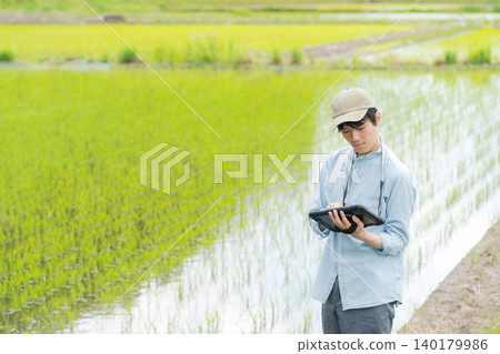 A young man uses a tablet to farm. 140179986