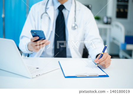 Medical technology concept. Doctor working with mobile phone and stethoscope in modern office Medical technology concept. Doctor working with mobile phone and stethoscope in modern office 140180019