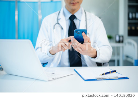 Medical technology concept. Doctor working with mobile phone and stethoscope in modern office Medical technology concept. Doctor working with mobile phone and stethoscope in modern office 140180020