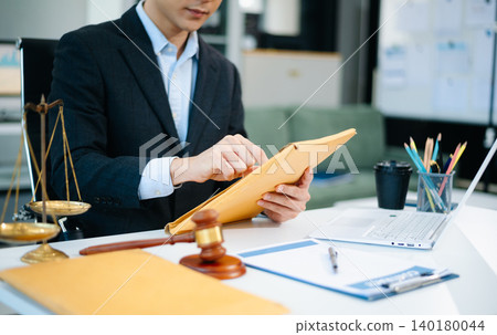 justice and law concept.law the me wooden desk, books, balance. Male judge in a courtroom the gavel,working with digital tablet computer 140180044